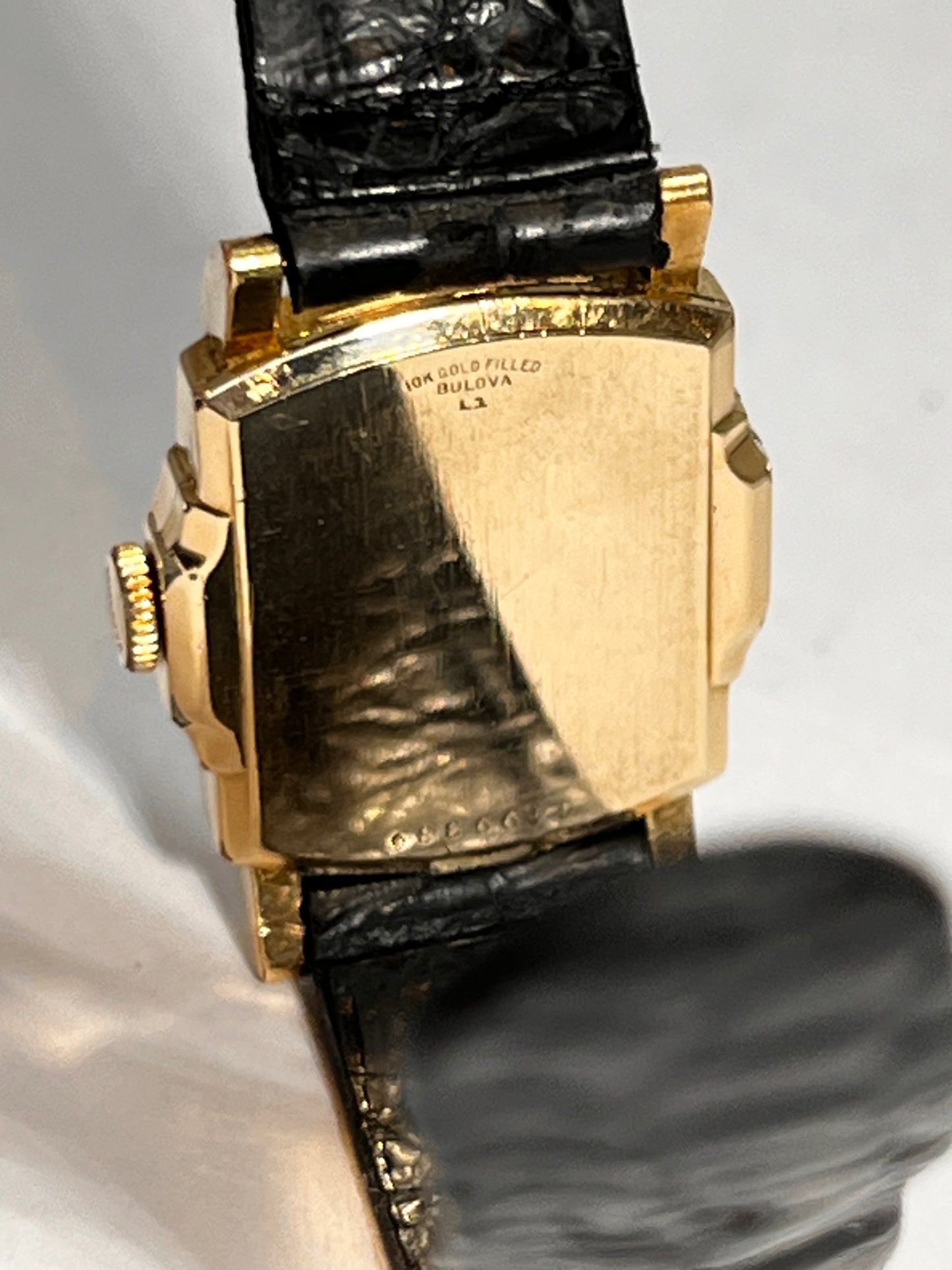 Close-up of the back of a gold-filled Bulova Academy Award Z wristwatch with a black alligator leather strap